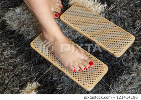 Woman's foot stands on nails on sadhu board during meditation class  121414180
