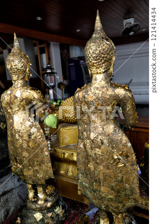 Wat Pho Temple In Thailand, it is customary to put gold leaf on Buddha statues when praying. Wat Pho Temple In Thailand, it is customary to put gold leaf on Buddha statues when praying. 121414434