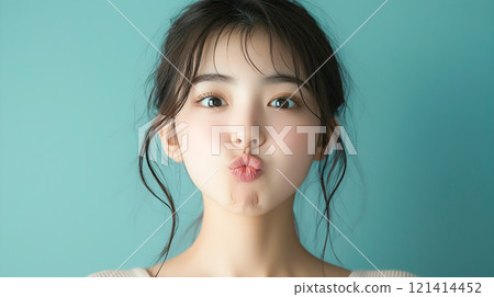 Young woman making a funny face with her mouth pursed 121414452