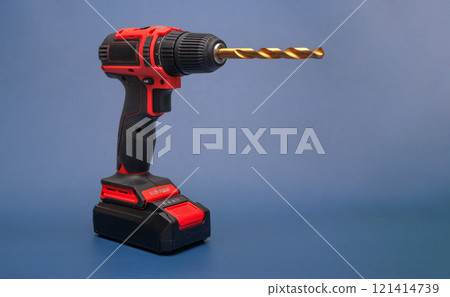 electric cordless screwdriver with a metal drill on a blue. isolate electric cordless screwdriver with a metal drill on a blue. isolate 121414739