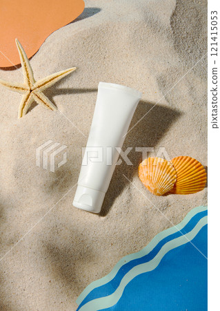 Top-down image of a white unmarked tube on a sandy beach with paper-cut ocean waves, starfish, and shells. An advertisement for sunscreen featuring a beach in the sun. Top-down image of a white unmarked tube on a sandy beach with paper-cut ocean waves, starfish, and shells. An advertisement for sunscreen featuring a beach in the sun. 121415053