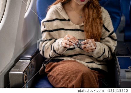 A close-up of a woman taking an airsick pill at her seat before the flight takes off. 121415250