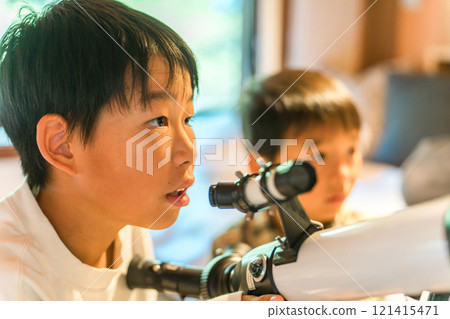 Children playing with a telescope during summer vacation (cottage, villa, mountain hut, camping, glamping) 121415471