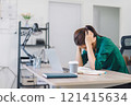 Stressed woman working at home desk, looking at notebook and laptop, managing tasks in home office. 121415634