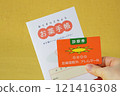 Medicine notebook and patient registration card in hand 121416308