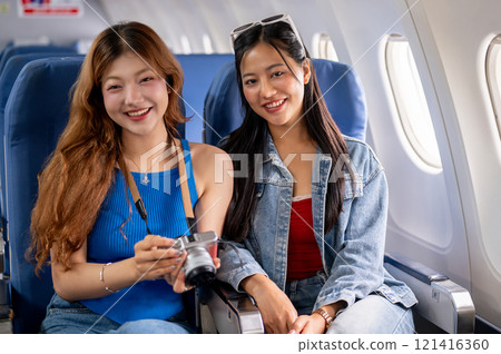 Two pretty and happy Asian females traveling on vacation together, smiling at the camera. Two pretty and happy Asian females traveling on vacation together, smiling at the camera. 121416360