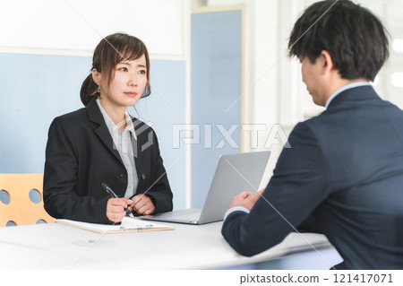 A managerial businesswoman and a young businessman having an interview, a job interview, a personnel evaluation, and a meeting A managerial businesswoman and a young businessman having an interview, a job interview, a personnel evaluation, and a meeting 121417071