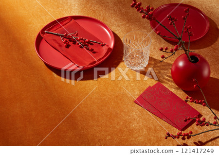 Top shot on yellow tabletop, some new year decorative accessories such as blank dish, glass, lucky money envelope and flower flat lay on which. Blank space for product displaying and adding text Top shot on yellow tabletop, some new year decorative accessories such as blank dish, glass, lucky money envelope and flower flat lay on which. Blank space for product displaying and adding text 121417249