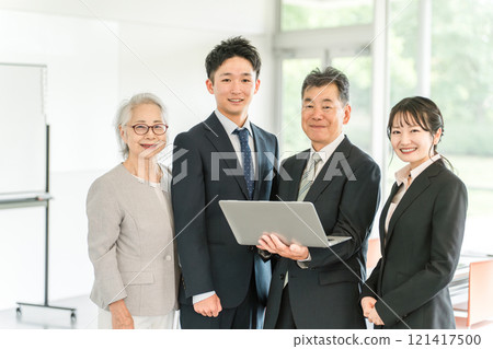使用電腦的老年人和年輕商人(家族管理、繼承人、企業繼承、繼承、出售、收購、代際更替) 使用電腦的老年人和年輕商人(家族管理、繼承人、企業繼承、繼承、出售、收購、代際更替) 121417500