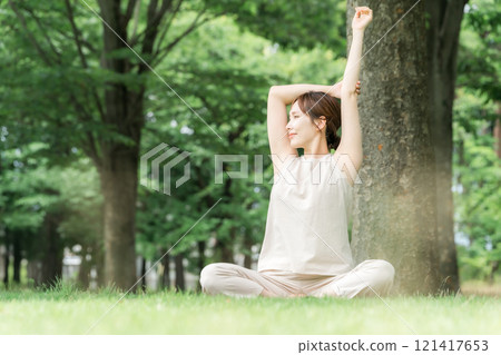 一位女士在森林裡做瑜伽、普拉提、森林浴、體操、伸展運動和鍛煉 一位女士在森林裡做瑜伽、普拉提、森林浴、體操、伸展運動和鍛煉 121417653