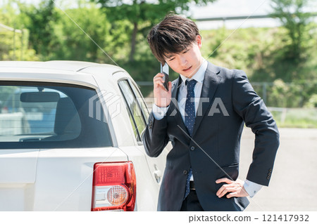 Young Asian man calling on smartphone in front of car (road service, trouble, rescue, trouble) Young Asian man calling on smartphone in front of car (road service, trouble, rescue, trouble) 121417932