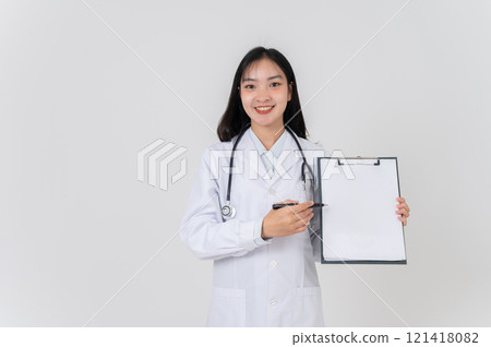 A positive Asian female doctor showing a blank medical clipboard to the camera. 121418082