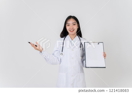 A positive Asian female doctor showing a blank medical clipboard to the camera. 121418083