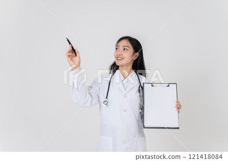 A positive Asian female doctor showing a blank medical clipboard to the camera. 121418084