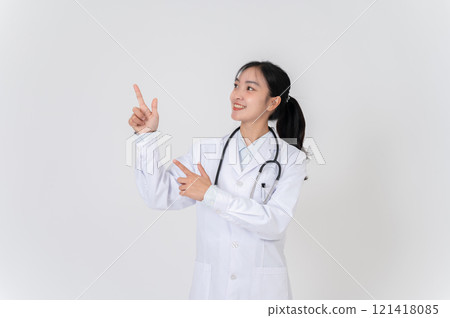A doctor in uniform smiling and pointing at an empty space, as if she is recommending something. 121418085