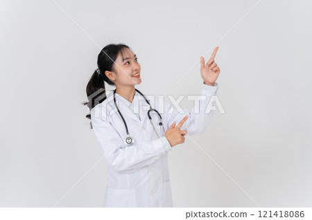 A doctor in uniform smiling and pointing at an empty space, as if she is recommending something. 121418086