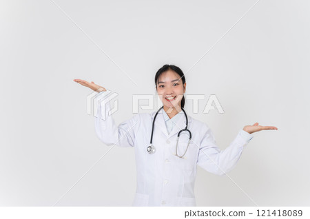 A female doctor smiling warmly and presenting with open palms, as if recommending something. 121418089