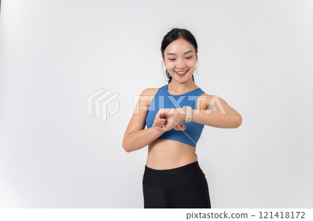 A smiling Asian woman in sportswear checking her workout calories burned on her smartwatch. A smiling Asian woman in sportswear checking her workout calories burned on her smartwatch. 121418172