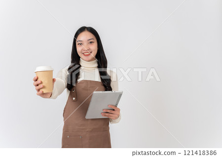 Attractive female coffee shop worker or waitress in a uniform holding a hot drink cup and a tablet. 121418386