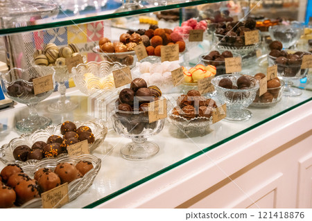 A showcase of beautifully arranged truffles and chocolates on glass plates A showcase of beautifully arranged truffles and chocolates on glass plates 121418876
