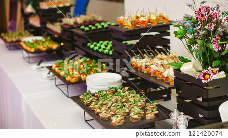 A contemporary hotel dining area featuring a sleek buffet setup. A contemporary hotel dining area featuring a sleek buffet setup. 121420074