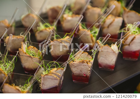 A contemporary hotel dining area featuring a sleek buffet setup. A contemporary hotel dining area featuring a sleek buffet setup. 121420079