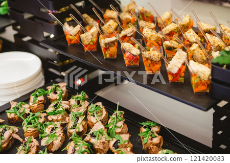 A contemporary hotel dining area featuring a sleek buffet setup. A contemporary hotel dining area featuring a sleek buffet setup. 121420083