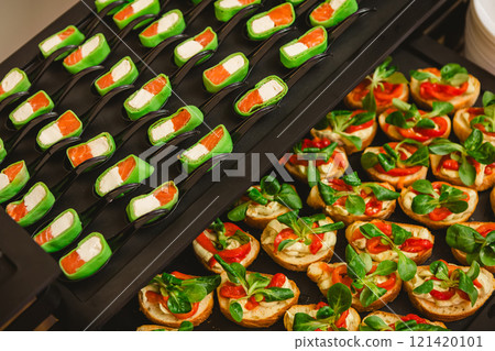 Platter of gourmet appetizers featuring pieces of salmon and cream cheese wrapped in a green wrap 121420101