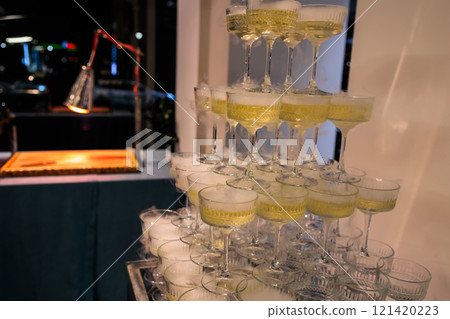 Towering pyramid of champagne glasses filled with bubbly Towering pyramid of champagne glasses filled with bubbly 121420223