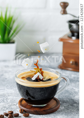 refined sugar falling into cup of coffee with splashes 121420637