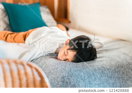 Child/boy lying on bed (villa/cottage/family trip) 121420888