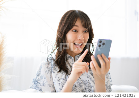 拿著智慧型手機的長黑髮的年輕女子 121421022