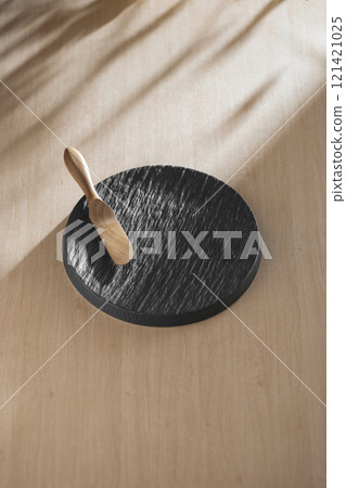 Various tableware on a soft wood-toned table background with sunlight shining through. Various tableware on a soft wood-toned table background with sunlight shining through. 121421025