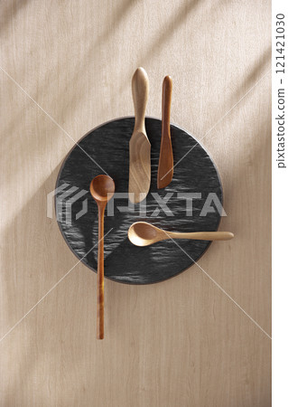 Various tableware on a soft wood-toned table background with sunlight shining through. Various tableware on a soft wood-toned table background with sunlight shining through. 121421030