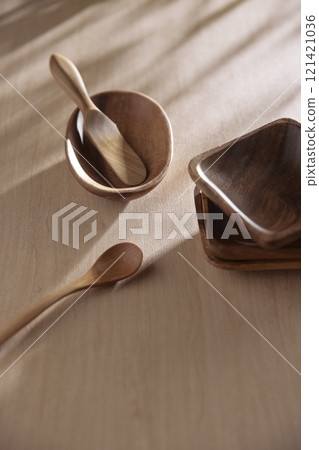 Various tableware on a soft wood-toned table background with sunlight shining through. Various tableware on a soft wood-toned table background with sunlight shining through. 121421036