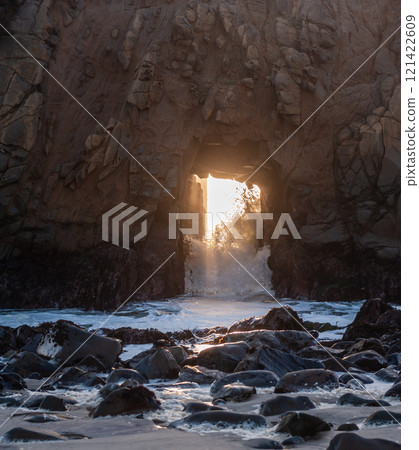 Setting sun peeping through keyhole arch 121422609