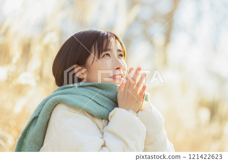 A woman warming her hands because she's cold 121422623