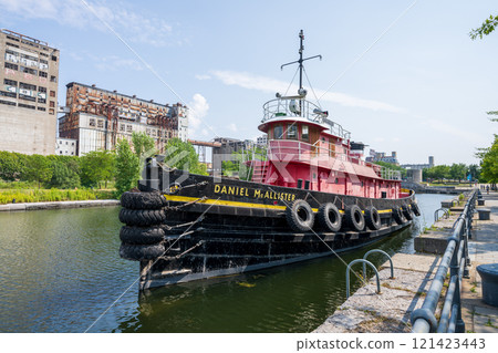 Montreal, Quebec, Canada - August 5 2021 : The tugboat Daniel McAllister, permanently moored in the Lachine Canal National Historic Site in Old Port of Montreal. Montreal, Quebec, Canada - August 5 2021 : The tugboat Daniel McAllister, permanently moored in the Lachine Canal National Historic Site in Old Port of Montreal. 121423443