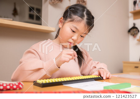 Elementary school student using abacus at a desk 121423527
