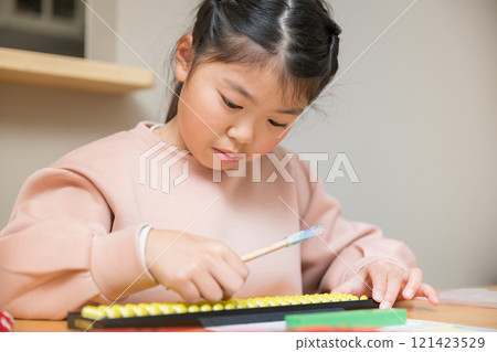 Elementary school student using abacus at a desk 121423529