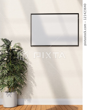 A minimalist interior with a blank frame on a wall beside a potted plant, with warm wooden flooring and soft light casting shadows. 3D rendering 121423640