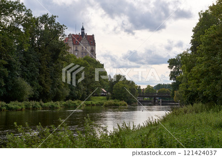 Picturesque Schloss Hohenzollern Castle Overlooking Tranquil River and Historic Bridge in Scenic German Countryside 121424037