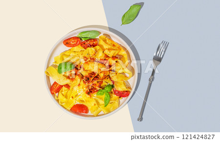 Tagliatelle or pappardelle pasta with tomato sauce, basil and parmesan cheese in a plate Tagliatelle or pappardelle pasta with tomato sauce, basil and parmesan cheese in a plate 121424827