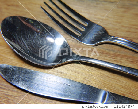 Fork, spoon and knife on a wooden table 121424874
