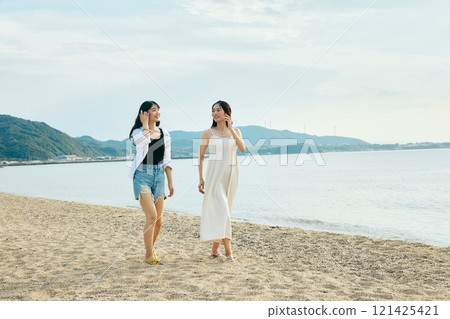 Woman walking on the beach in summer 121425421
