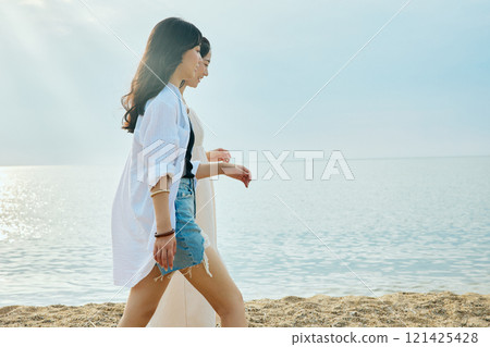 Woman walking on the beach in summer 121425428