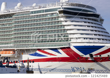 Cruise ship. Boat. Vacation and travel concept with a generic cruise ship sailing on the calm ocean. Luxury cruise liner. Cargo sea port and container terminal. Large cranes on a commercial dock. 121425489