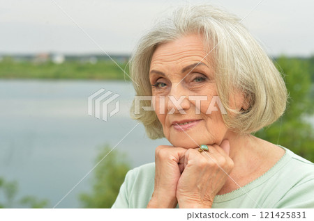 Portrait of a beautiful elderly woman in the park 121425831
