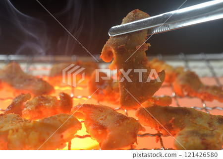 Grilled offal on a charcoal grill with rising smoke 121426580