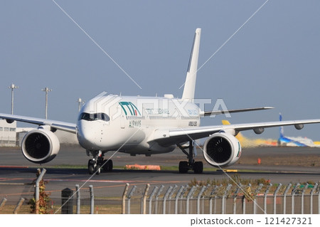 A passenger plane heading to the runway A passenger plane taxiing to a spot 121427321